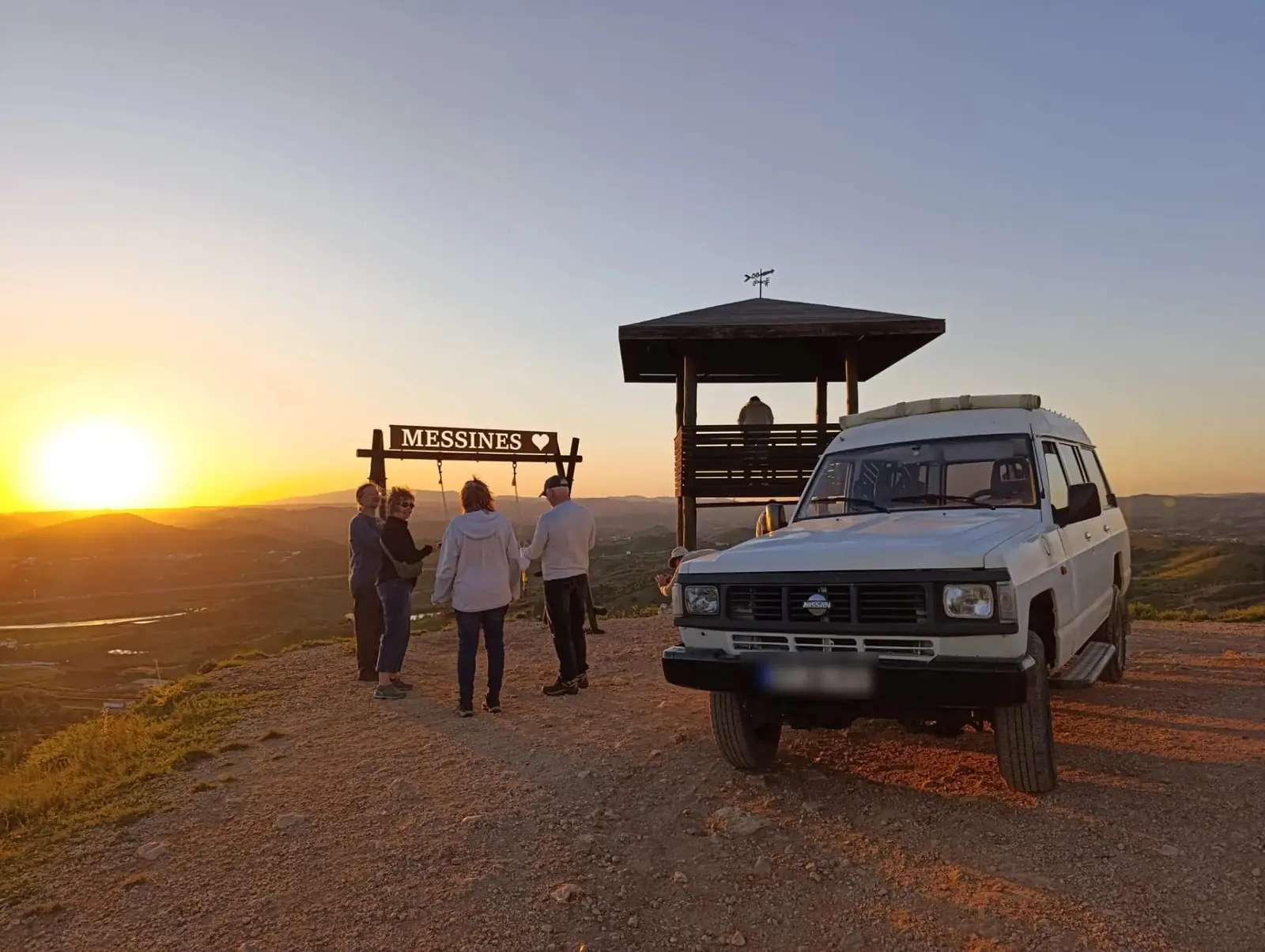 4x4 with moonroof at a hilltop viewpoint in the Algarve at sunset